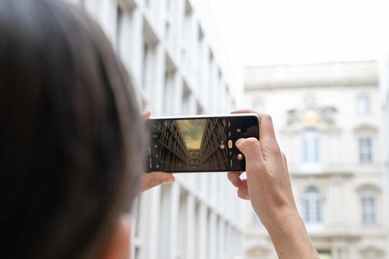 Femme prenant une photo avec son téléphone portable à Berlin
